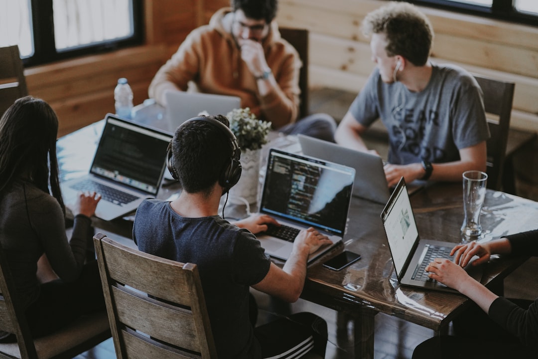 A collections and recovery operations team reviewing customer case files together on laptops, representing the human-supervised arrears workflows that on-premises AI agents support inside a lender's own security boundary