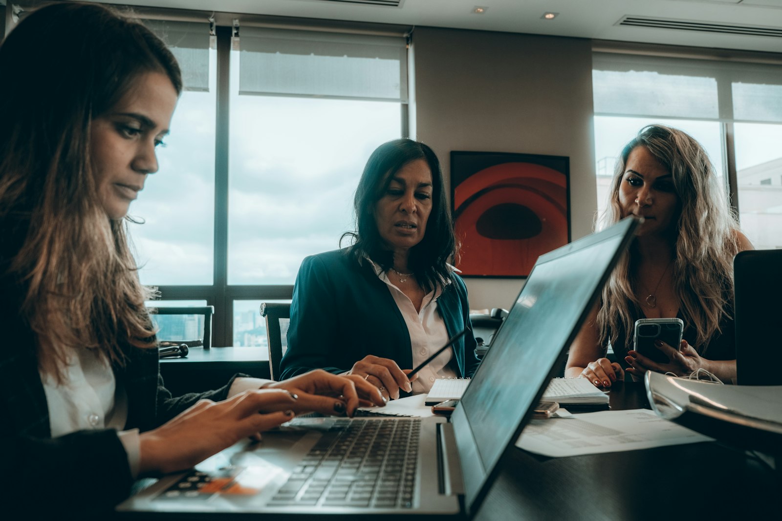 Enterprise legal and business team collaborating around a laptop, representing a governed AI agent workflow for contract review and approval running inside the organization's own security boundary