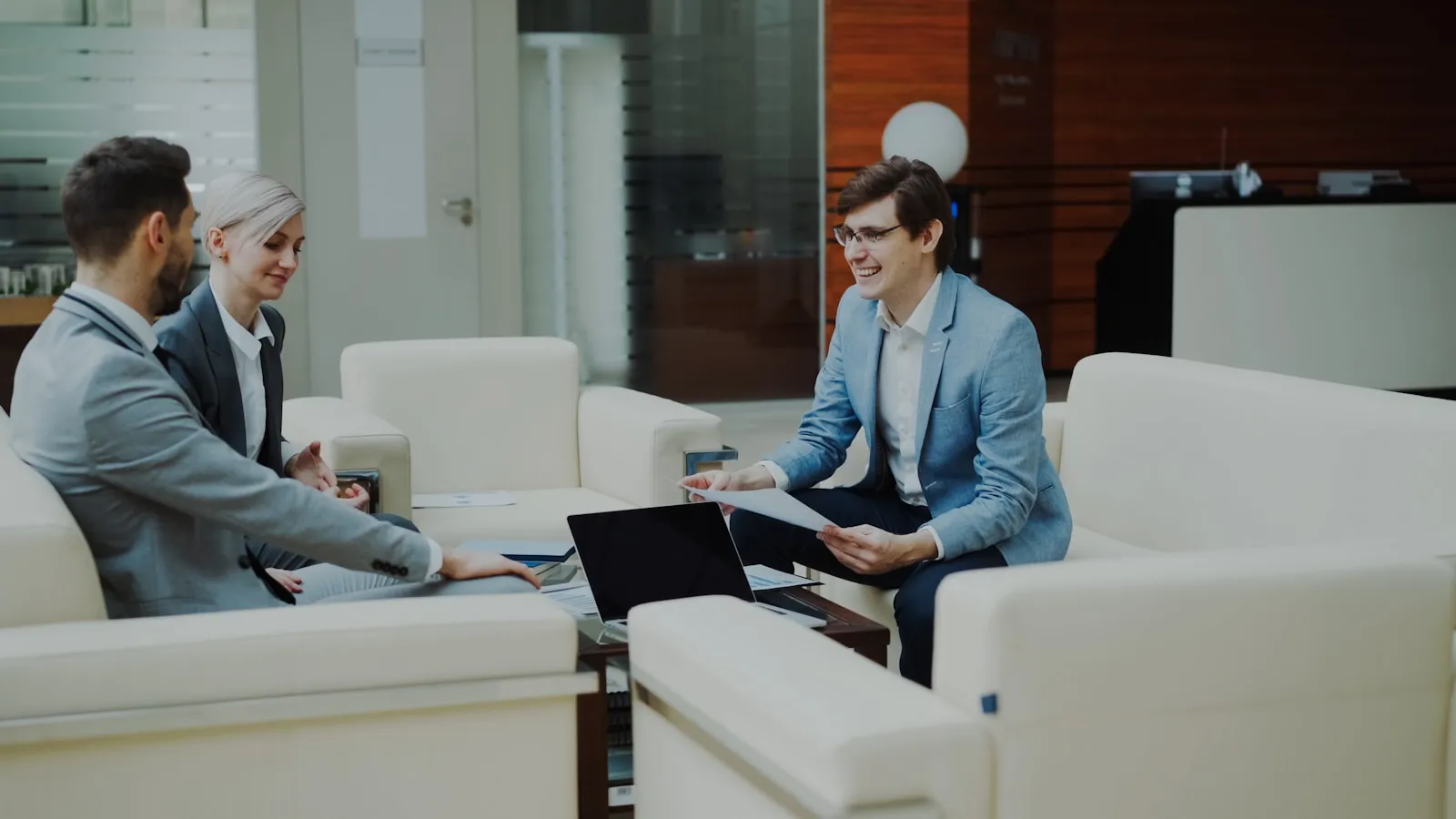 Three colleagues reviewing a request together in a modern office, representing the internal service desk workflows that on-premises AI agents support inside the enterprise security boundary