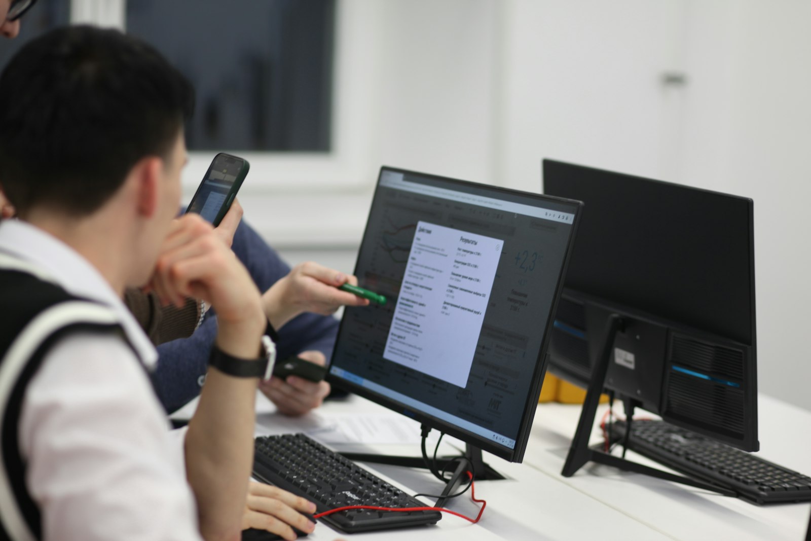 Finance operations team reviewing data and figures on a monitor together, representing governed AI agents automating order-to-cash steps inside an organization's own secure, on-premises environment