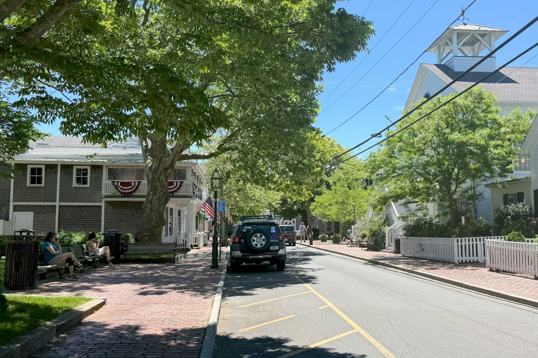A quiet small-town main street lined with trees, shops and a white church steeple, the kind of community many credit unions serve