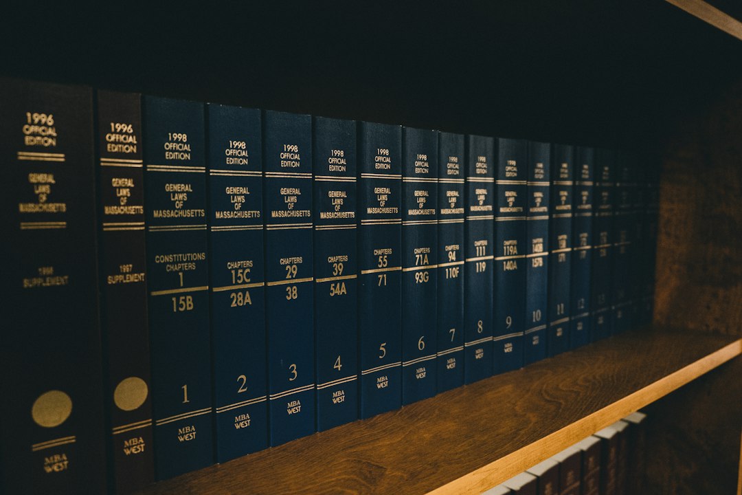 Rows of bound volumes of state statutes on a dark wooden shelf in a law library