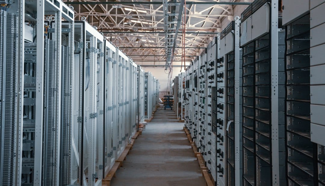 A long aisle between rows of metal server racks, the kind of self-hosted infrastructure where a RAG team keeps its vector index next to the documents it was built from