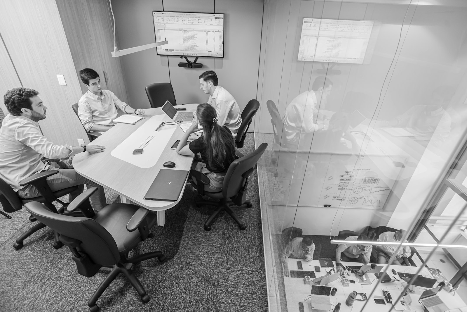 Enterprise decision-makers reviewing figures together in a conference room, representing the business-case and ROI analysis behind investing in governed, on-premises AI workflow automation