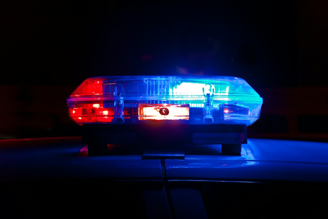 A police light bar glowing red and blue against a dark night background