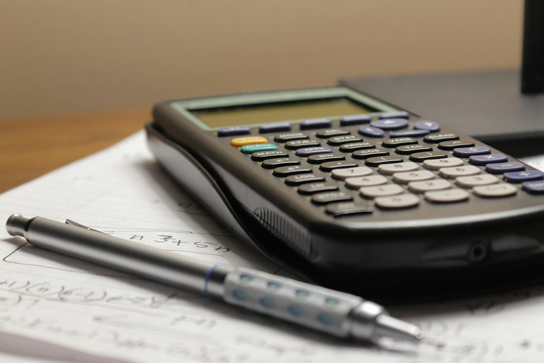 A scientific calculator and a mechanical pencil resting on handwritten sums, the kind of seat-cost arithmetic behind an enterprise AI subscription