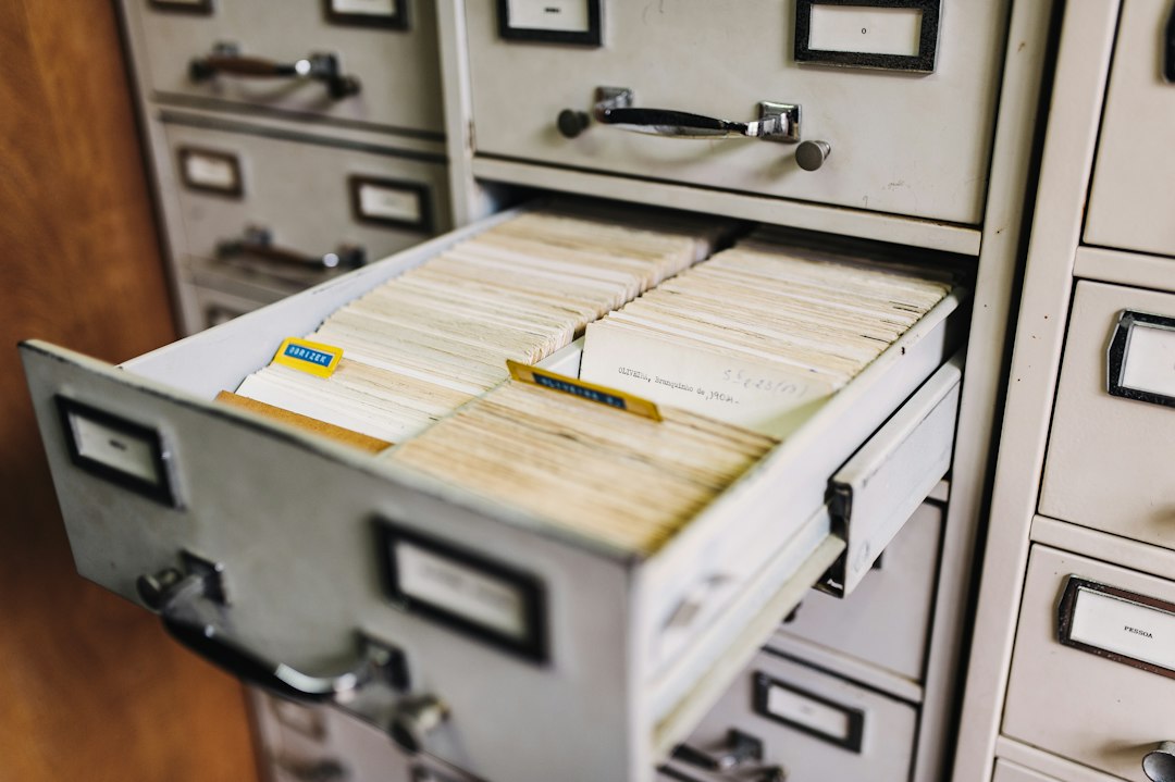 An open filing-cabinet drawer packed with index cards, representing the files and permissions an assistant connected to company data can reach