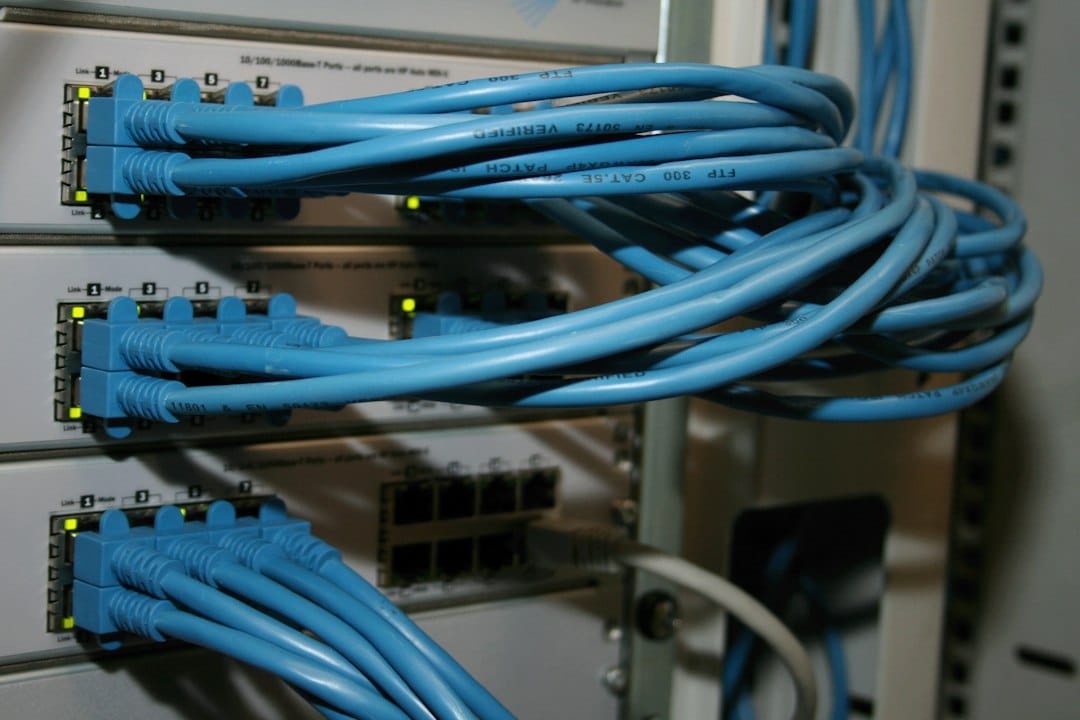 Bundles of blue network cables plugged into rows of rack-mounted switches, standing in for the gateway that routes every application's model calls