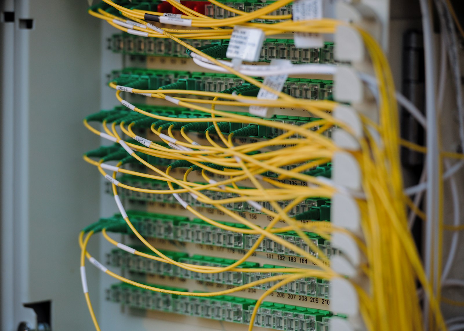 Neatly routed yellow and green network cables in a data center rack, representing the on-premises infrastructure where private RAG pipelines are evaluated and measured inside the enterprise security boundary