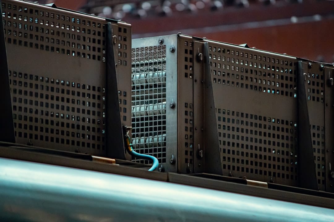 A row of ventilated metal equipment enclosures with a blue cable running between them, a reminder that power delivery and heat removal shape an on-premise AI server deployment as much as the GPUs inside it