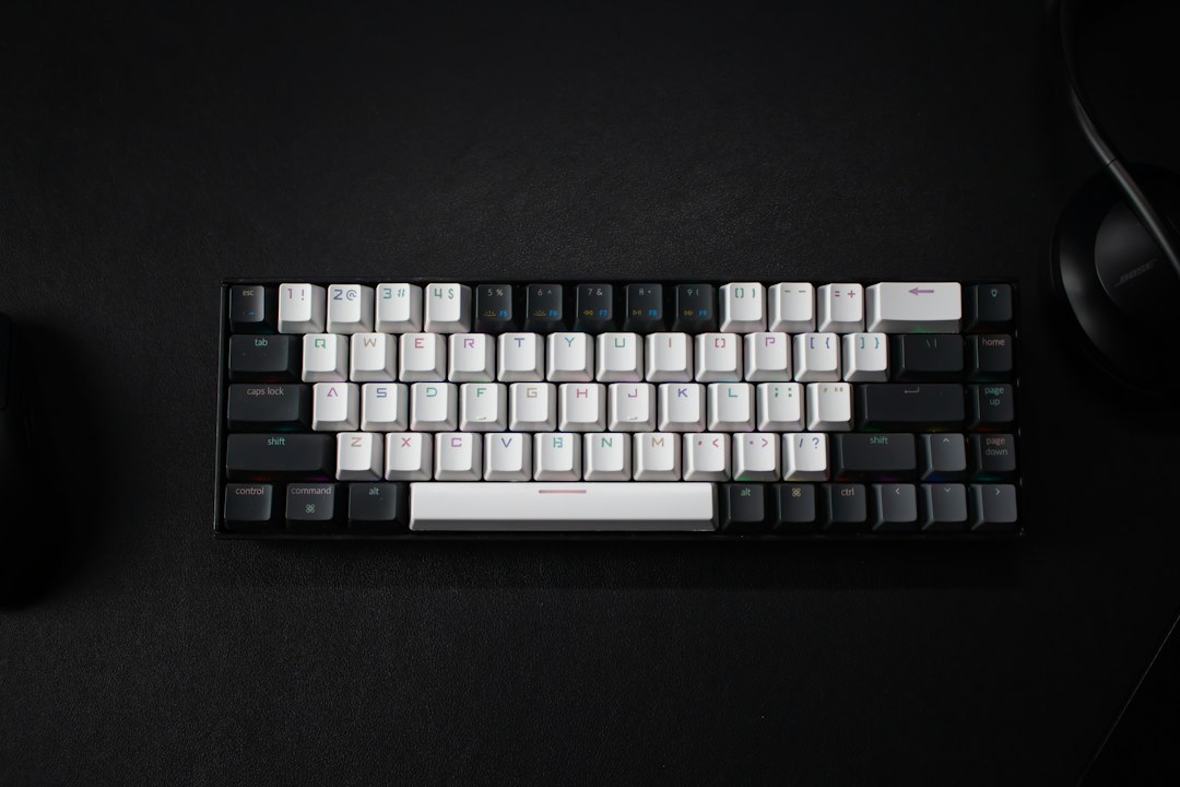 A compact black-and-white mechanical keyboard on a black desk mat, a nod to minimal terminal tools such as the Pi coding agent