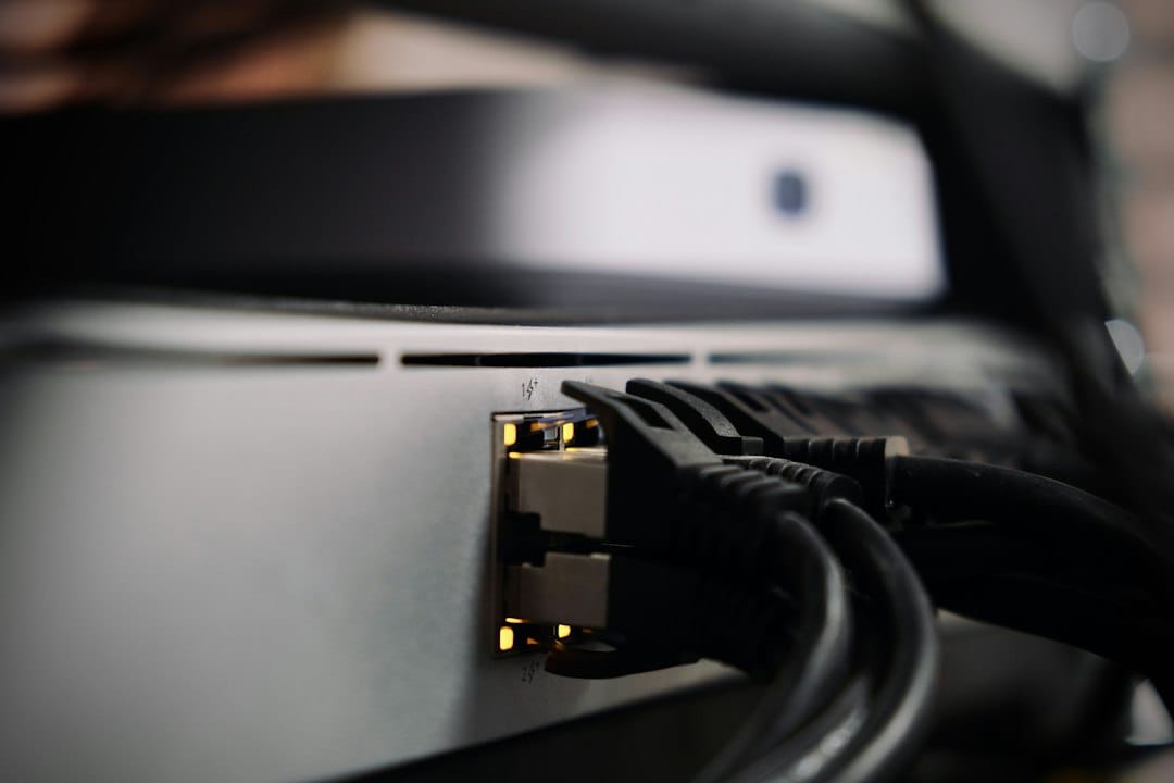 Black network cables plugged into the ports of a rack-mounted switch, a reminder that interconnect and power, not only GPU memory, separate a PCIe workstation card from an SXM data-centre GPU
