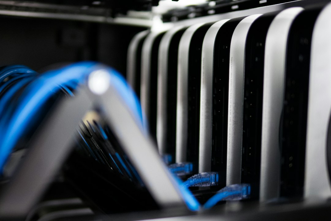 A row of compact computers racked side by side with blue network cables, representing the isolated execution environments that AI agents need when they run code in private infrastructure