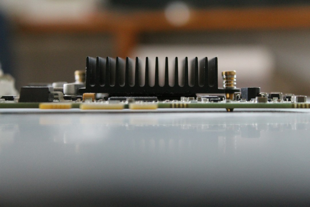 Close-up of a black heatsink on a circuit board against a soft grey background, representing the GPU hardware that local fine-tuning and inference apps run on