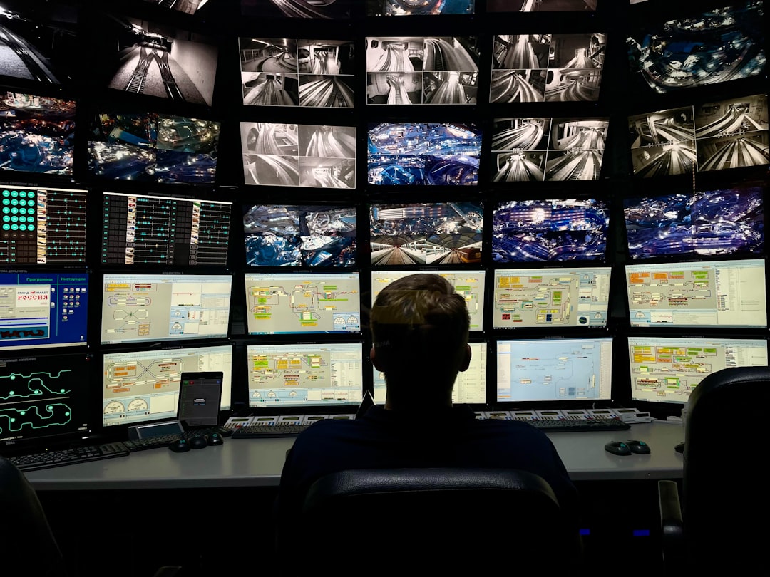 Security operator monitoring a wall of network and infrastructure screens in a control room, representing zero-trust network monitoring for on-premises AI workloads
