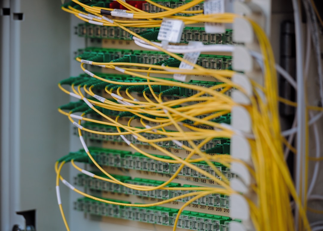 Dense network of yellow and green data cables neatly connected in a server rack, representing the structured, governed infrastructure required for enterprise AI agent platform deployments